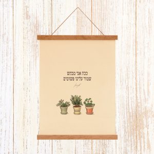 הדפסה ייחודית על בד קנבס בין מוטות עץ כפריים לתלייה על קיר באווירה כפרית וטבעית עם מילות השיר של עקיבא ככה אני מבקש שמור עלינו פשוטים עם איור עציצם קליל