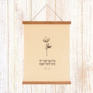 הדפסה ייחודית על בד קנבס בין מוטות עץ כפריים לתלייה על קיר באווירה כפרית וטבעית עם מילות השיר של מאיר אריאל מודה אני לפניך ולך על הכל החסד והאמת עם איור כותנה בוטני