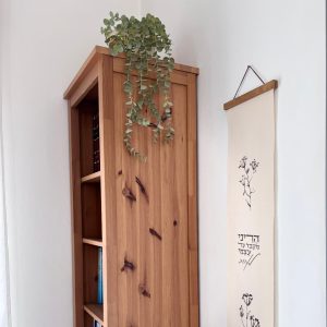 הדפסה ייחודית על בד קנבס בין מוטות עץ כפריים לתלייה על קיר באווירה כפרית וטבעית בפורמט צר ואורך מתאים לתליה על קיר צר במעברים עיצוב מיוחד עם המילים הרני מקבל על עצמי לאהובאיורים פשוטים עדינים רישום חום של צמחים כפרי חום