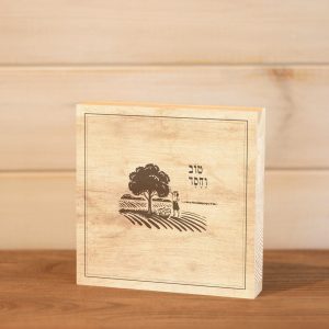 בלוק עץ ריבוע עם הכיתוב טוב וחסד להנחה על מדף או תליה בעיצוב נקי כפרי עם איור אוספת תפוזים בפרדס